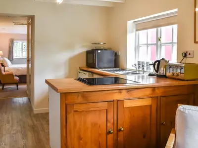 a kitchen with a sink and a stove top oven at Little House On The Common in Wortham