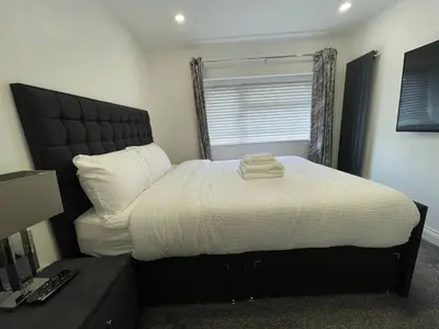 a bedroom with a large bed with white sheets at Luxurious 2 bed home in Basildon in Basildon