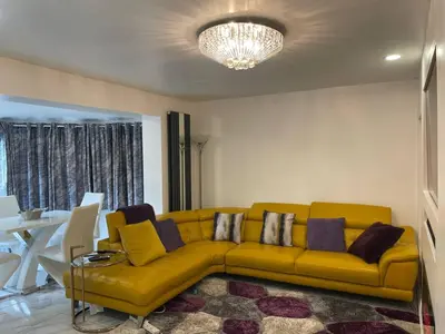 a living room with a yellow couch and a table at Luxurious 2 bed home in Basildon in Basildon