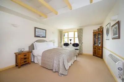 a bedroom with a large bed and a window at The Granary at Pannels Ash Farm in Sudbury