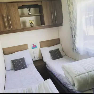 two beds in a small room with a window at Kjs holiday home in Saint Osyth