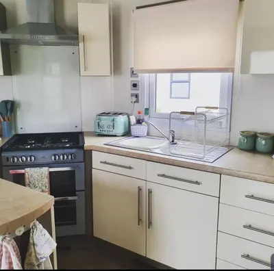 a kitchen with a sink and a stove top oven at Kjs holiday home in Saint Osyth