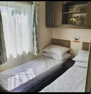 two beds in a small room with a window at Kjs holiday home in Saint Osyth