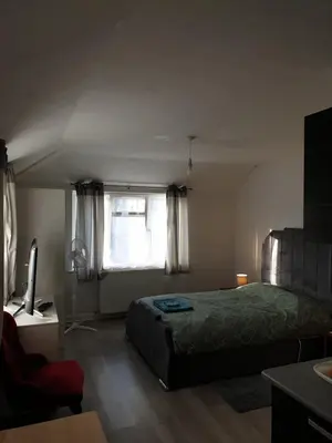 a bedroom with a bed and a television and a window at Studios in Ely