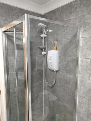 a shower with a shower head in a bathroom at Studios in Ely
