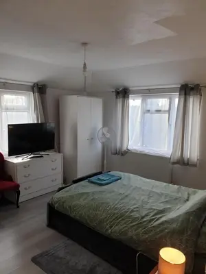 a bedroom with a bed and a flat screen tv at Studios in Ely