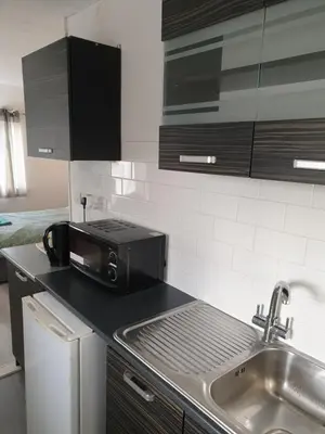 a kitchen with a sink and a microwave at Studios in Ely
