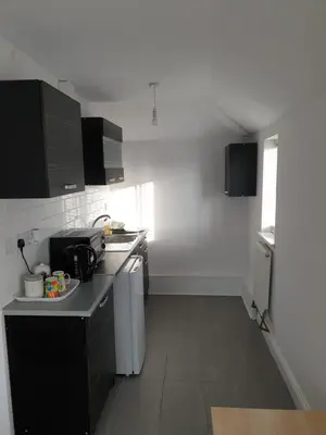 a small kitchen with black and white appliances at Studios in Ely