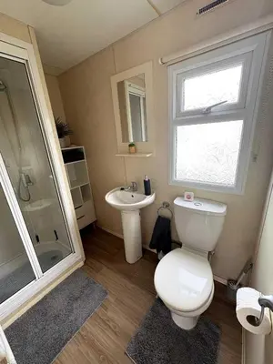 a bathroom with a toilet and a sink at Modern Caravan With Wifi At Seawick holiday park, Clacton on Sea 8 berth Large Decking in Clacton-on-Sea