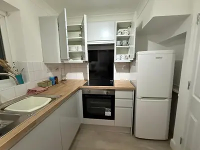a white kitchen with a sink and a refrigerator at Contractor, families and bikes in Earith
