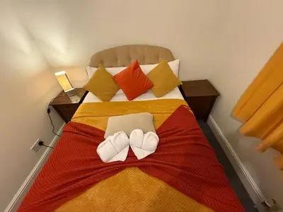 a bedroom with a bed with two towels on it at Contractor, families and bikes in Earith