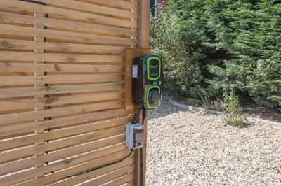 a wooden fence with a pay phone on it at Wonderful cottage with sun-filled terrace in Aldringham