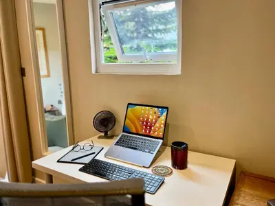 a laptop computer sitting on a desk with a keyboard at Modern, Gr Floor 1 bed, bathroom, garden & private entry with Free Parking in Cambridge