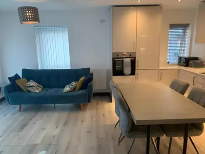 a living room with a blue couch and a table at Raphvin Apex Abode - Two bedroom apartmentparking in Harlow