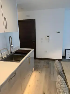 a kitchen with a sink and a counter with chairs at Raphvin Apex Abode - Two bedroom apartmentparking in Harlow