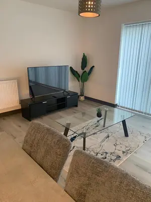 a living room with a glass table and two chairs at Raphvin Apex Abode - Two bedroom apartmentparking in Harlow