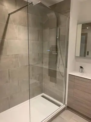 a shower with a glass door in a bathroom at Raphvin Apex Abode - Two bedroom apartmentparking in Harlow