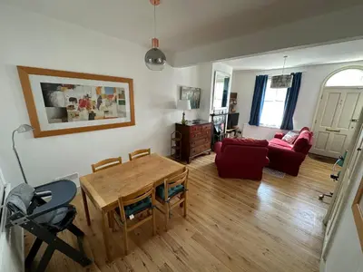 a living room with a table and a red couch at Beautiful Victorian house in central Cambridge in Cambridge