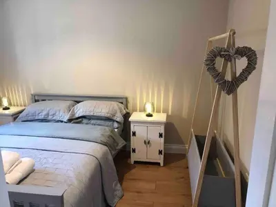 a bedroom with a bed and a heart on the wall at The Cottage in Birdbrook