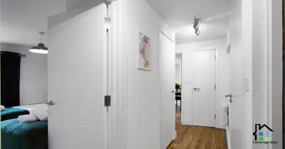 a white room with a bed and a hallway at R&O Property Experts - Riverside - 2 & 3 BR - Flat Walk to Centre with open Parking in Cambridge