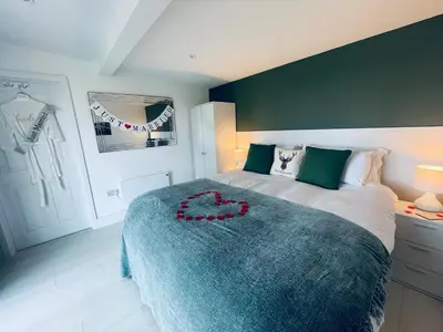 a bedroom with a large bed with a blue blanket at The Hideaway-Perfect Staycation in Belchamp Saint Paul