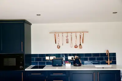 a kitchen with blue tiled walls and utensils at The Hideaway-Perfect Staycation in Belchamp Saint Paul