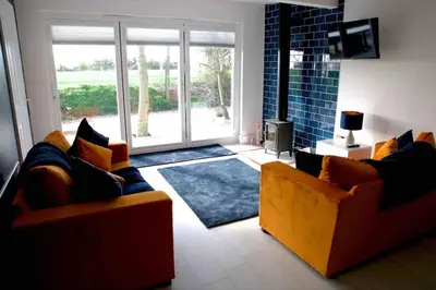 a living room with two couches and a sliding glass door at The Hideaway-Perfect Staycation in Belchamp Saint Paul