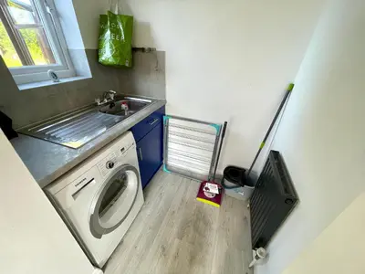 a small bathroom with a washing machine and a sink at Large 5 bed detached house near Stansted Airport with Parking for 2 vehicles! Stansted Stays in Stansted Mountfitchet