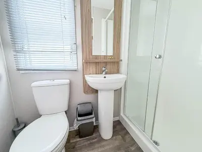 a bathroom with a toilet and a sink and a shower at Modern 8 Berth Caravan With Decking At Naze Marine Park, Essex Ref 17145P in Walton-on-the-Naze