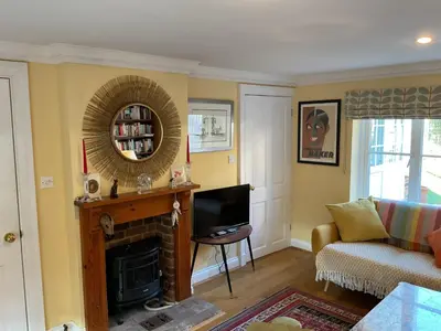 a living room with a fireplace and a mirror at Peaceful house ideal for dogs lovely location in Aldeburgh