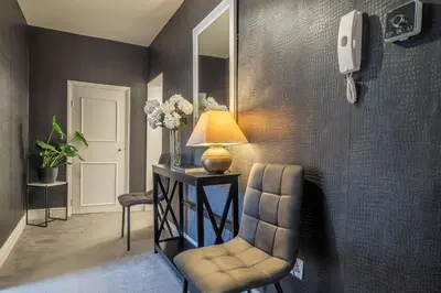 a living room with a chair and a mirror at Crown Street 4 in Bury Saint Edmunds