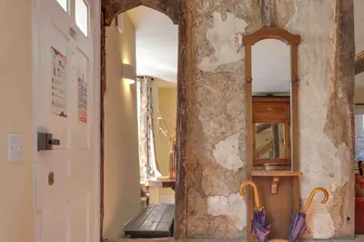 an entrance to a hallway with a mirror and an open door at Josua Medieval Living Maldon in Maldon