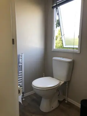 a bathroom with a white toilet and a window at Beach house fun in Walton-on-the-Naze