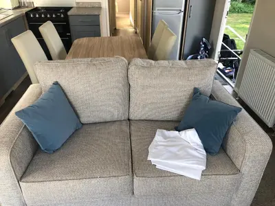a couch with two pillows and a table in a kitchen at Beach house fun in Walton-on-the-Naze