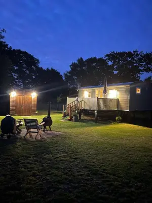 a couple of animals standing in the grass next to a trailer at Muffins Meadow Shepherds Hut in Tillingham