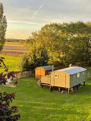 a group of tiny houses in a grass field at Muffins Meadow Shepherds Hut in Tillingham