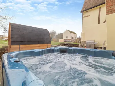 a hot tub in the backyard of a house at Sycamore Farmhouse in Ipswich
