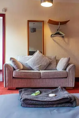 a living room with a couch and a mirror at The George Hotel in Chatteris