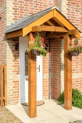 a wooden pergola with two potted plants on it at Hole in One in Aldeburgh