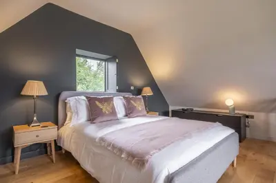 a bedroom with a large bed and a window at Granary Cottage in Wenhaston