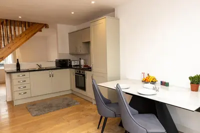 a kitchen with a table and chairs in a kitchen at The Poppies Cottage in Six Mile Bottom