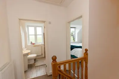 a bathroom with a sink and a toilet in a room at The Poppies Cottage in Six Mile Bottom