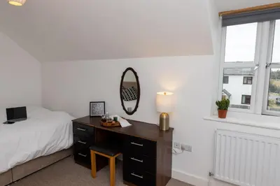 a bedroom with a desk and a bed and a mirror at The Poppies Cottage in Six Mile Bottom