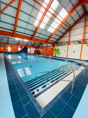 a large swimming pool in a large building at FV006 NALONGOS HOLIDAY HOME in Saint Osyth