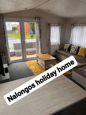 a living room with a couch and a table at FV006 NALONGOS HOLIDAY HOME in Saint Osyth