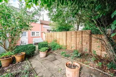 a garden with potted plants and a wooden fence at Lilac Cottage, Wenhaston in Halesworth