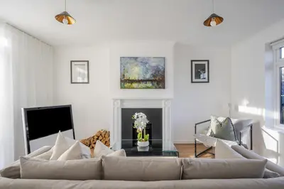 a living room with a couch and a fireplace at Luxurious 3 Bed House with Free Parking, Sky TV, Movies & Netflix in Braintree