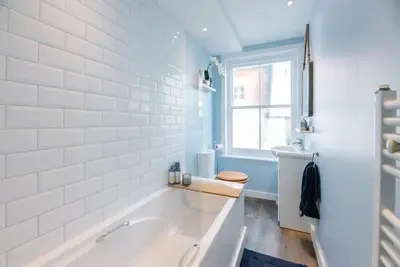 a bathroom with a tub and a toilet and a window at Seaway Cottage, Aldeburgh in Aldeburgh