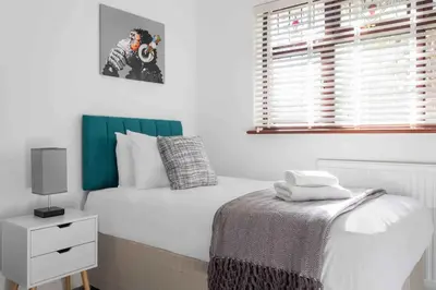 a bedroom with a white bed and a window at The Orange House Langdon Hills in Langdon Hills