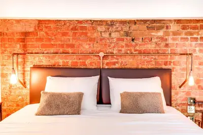 a bed in a room with a brick wall at Entire 3 Bedroom House Contractors Families Relocators in Ware